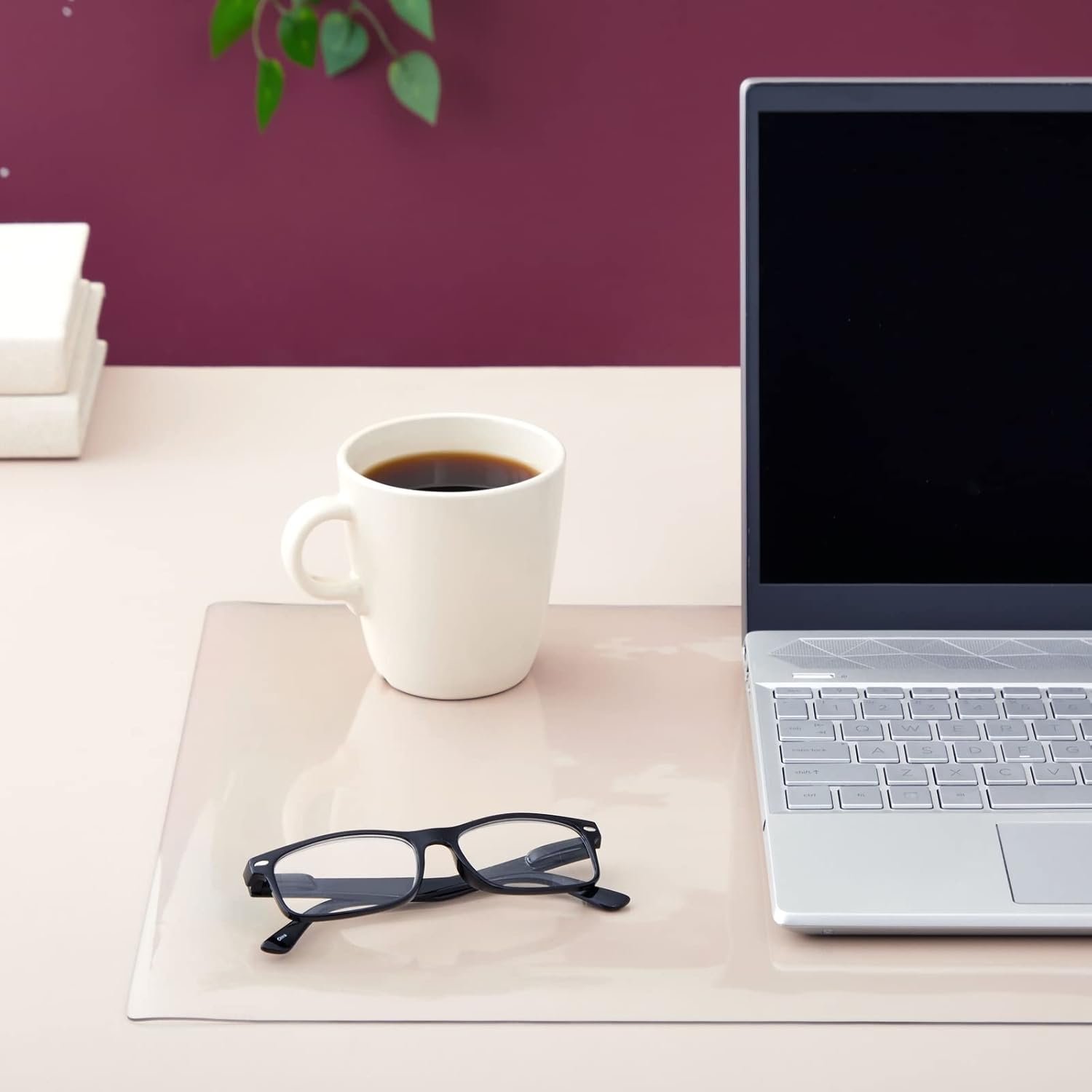 Frosted transparent desk mat under a laptop, coffee cup, and glasses on a light-colored desk