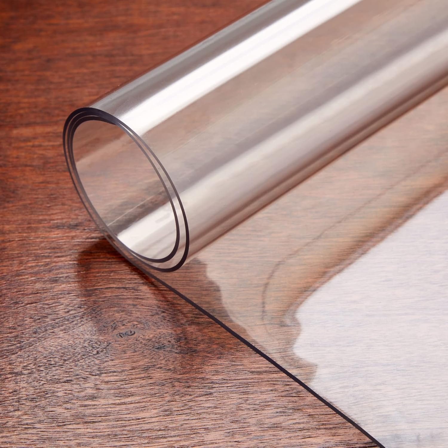 Frosted transparent desk mat rolled on wooden surface