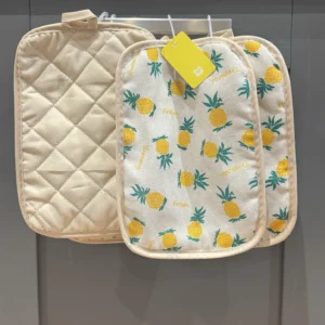 Set of heat resistant oven mitts pot holders for kitchen, one plain beige and two with pineapple print